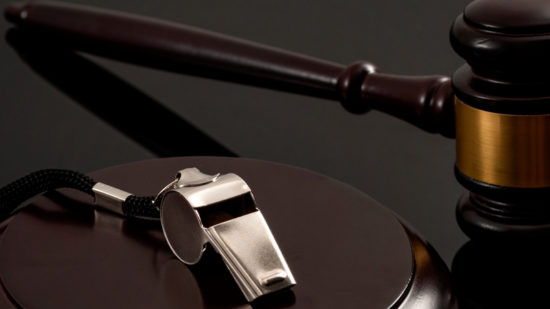 Whistleblower protection law and freedom of information legislation conceptual idea with metal whistle and wooden judge gavel on dark background